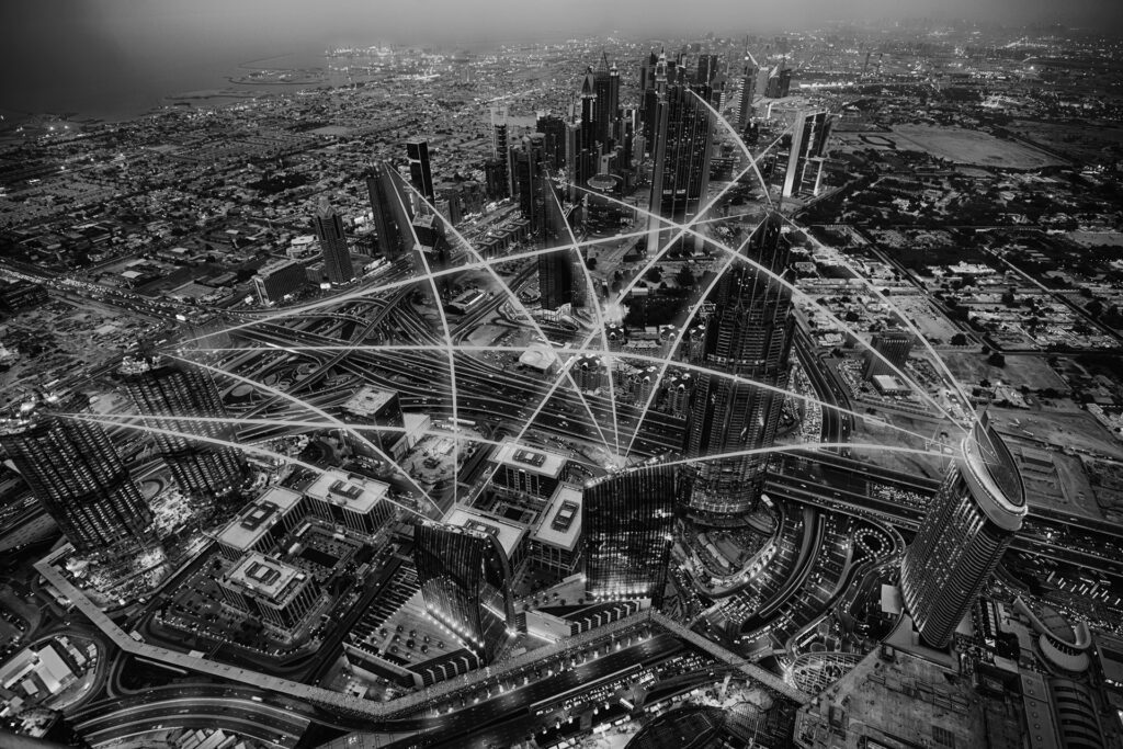 Aerial photograph of modern skyscrapers overlaid with glowing digital connections